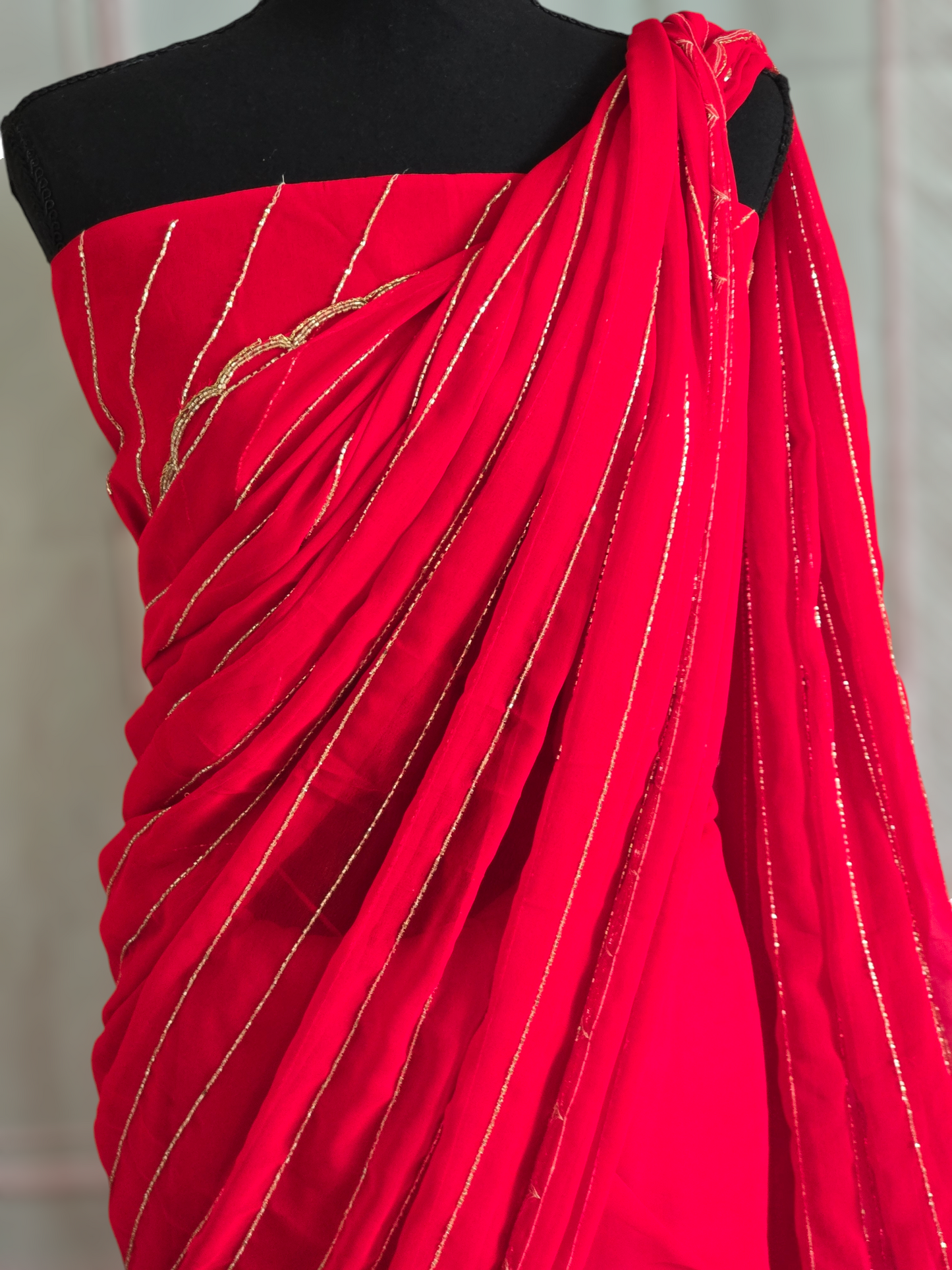 Bright red designer Georgette Saree with stitched sleeveless blouse